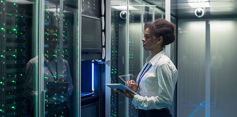 Female technician works on a tablet in a data center